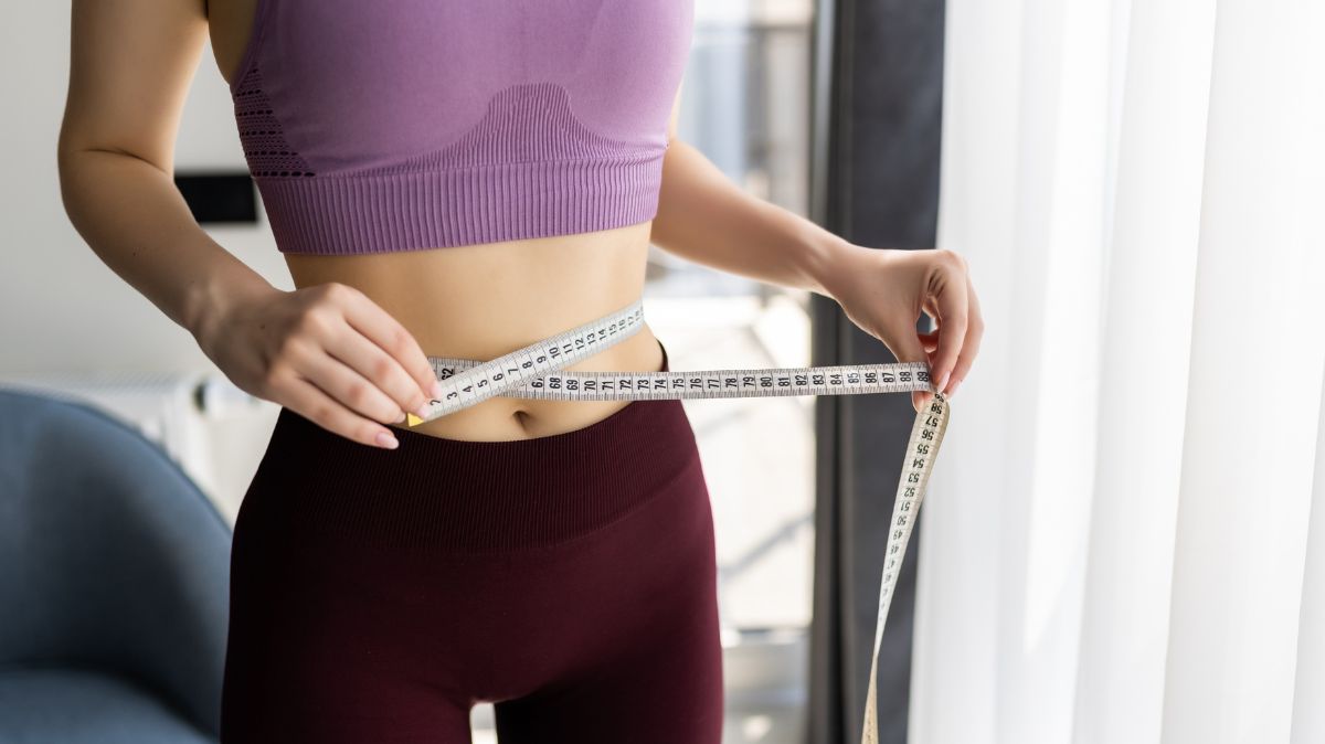 kobieta mierząca brzuch - dieta na płaski brzuch